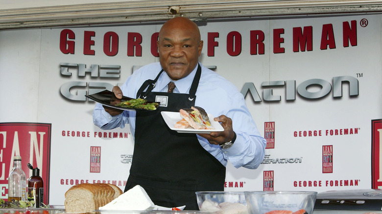 George Foreman at an event holding plates of food