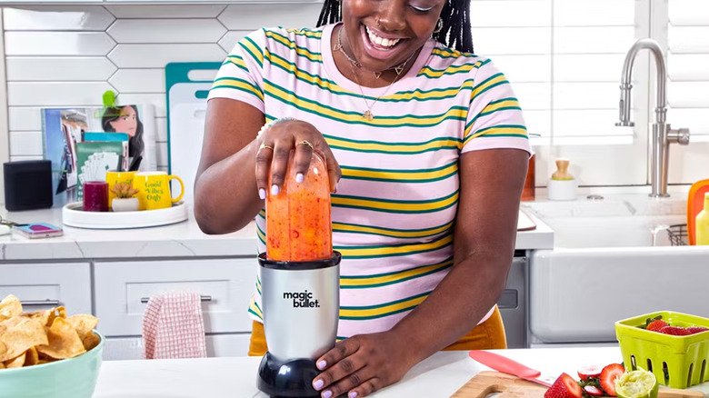 A woman mixing a smoothie in a Magic Bullet blender