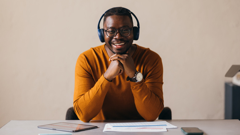 Man sitting at desk wearing headphones