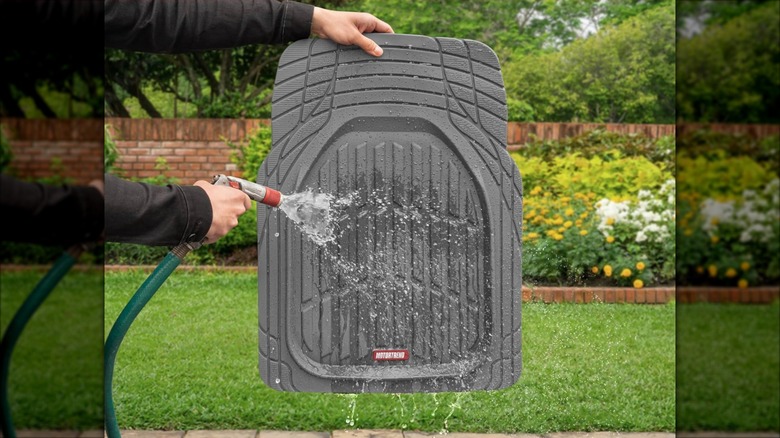 Gray Motor Trend car mat being cleaned