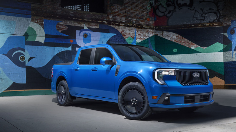 2026 Ford Maverick Lobo in front of wall with abstract graffiti, front-right 3/4 view