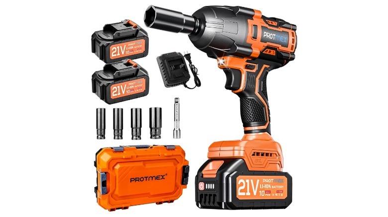 An orange and black impact wrench with a charger, two batteries, and a few sockets.