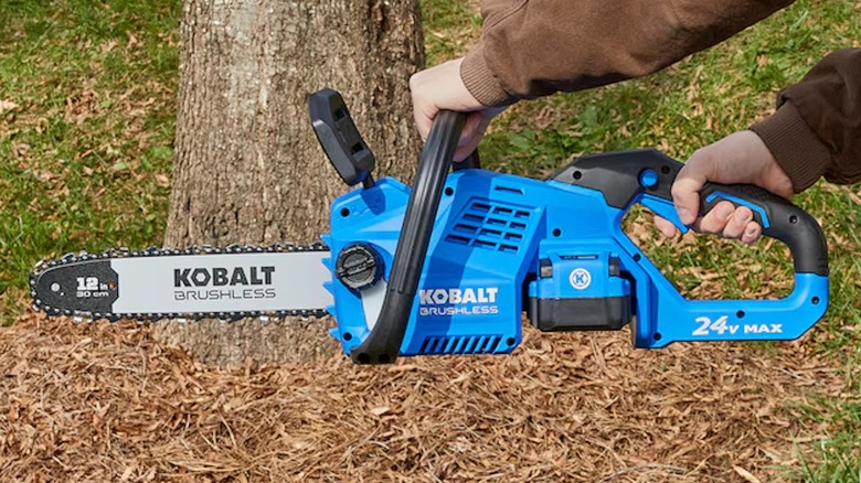 Kobalt 24V 12-inch Chainsaw being held