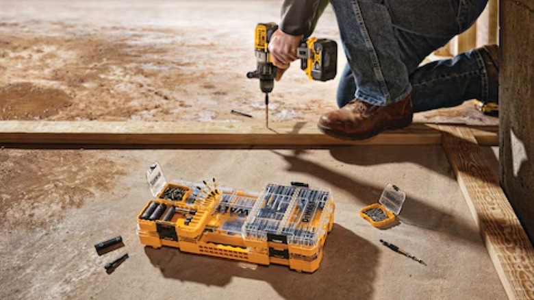 FlexTorq 40-piece Impact-Ready Screwdriving Bit Sets with Toughcase+ System beside worker using DeWalt drill