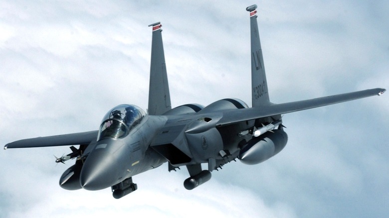 An F-15E Strike Eagle flying over clouds