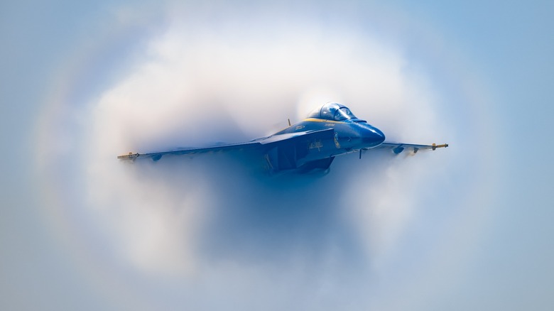 An F/A-18 Hornet surrounded by condensation clouds from its shockwaves