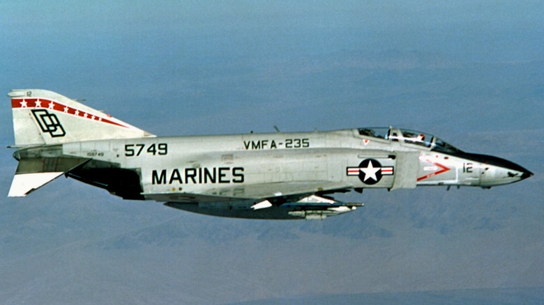 A McDonnell Douglas F-4S Phantom II flying over mountains in 1982
