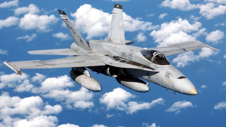 A McDonnell Douglas F/A-18C Hornet in flight over blue, cloudy skies