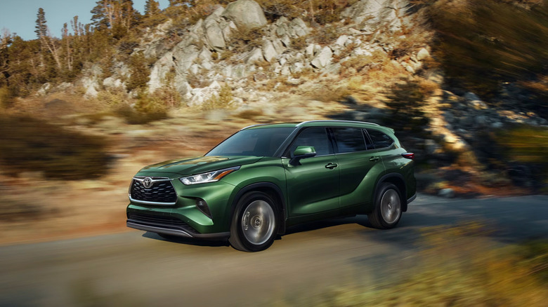 A gree n2025 Toyota Highlander driving