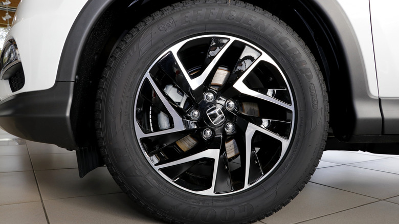 A front left corner of a white Honda SUV with Goodyear's EfficientGrip tires.