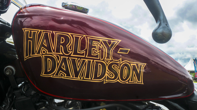 A red motorcycle with golden Harley-Davidson logo in the center