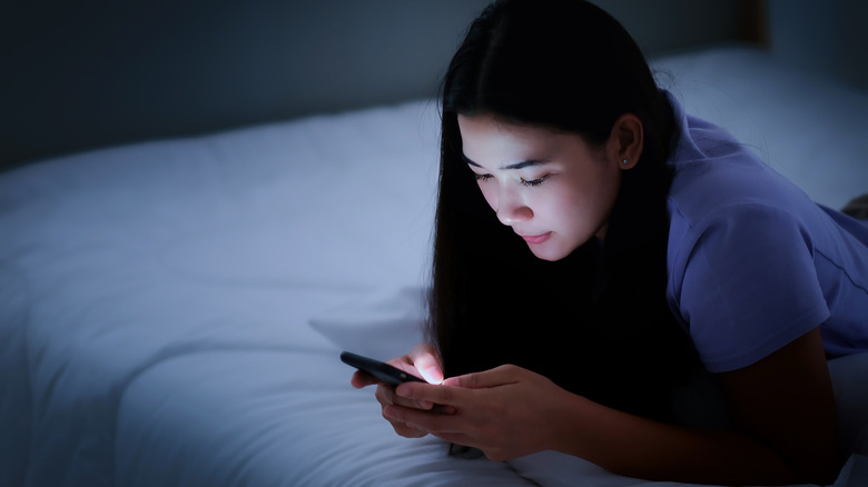 Person using phone in bed