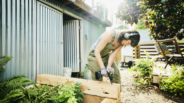 homeowner building garden infrastructure in yard