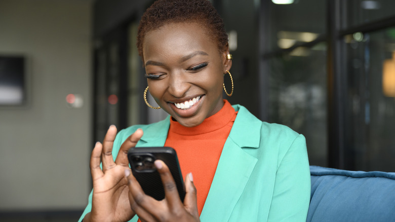 woman happily using iphone