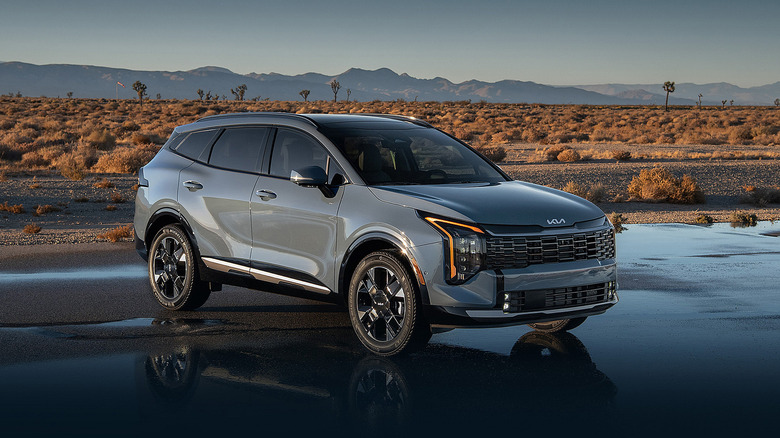 A gray Kia Sportage Hybrid on a wet road in the desert