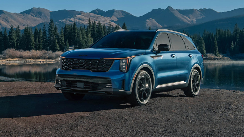 A blue Kia Sorento Hybrid by a lake