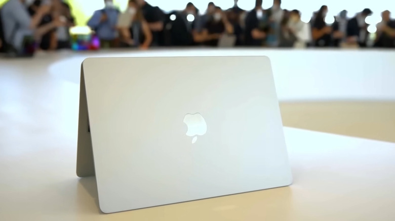 Starlight MacBook Air M2 on counter nearby several people