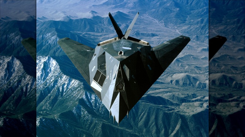 An F-117 Nighthawk flying over mountainous terrain in California in 2002