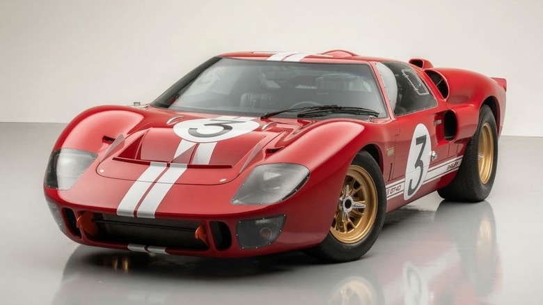 A red Superformance Ford GT40 restomod parked on display.