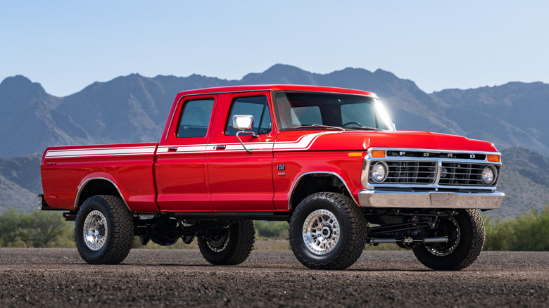 A restored red 1974 Ford pickup truck parked with mountains in the background.