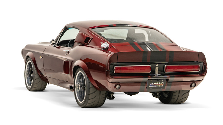 A rear three-quarter view of a red 1967 restomod Shelby GT500 parked in a studio.
