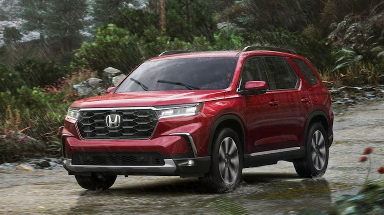 A red Honda Pilot driving in the rain on a spring