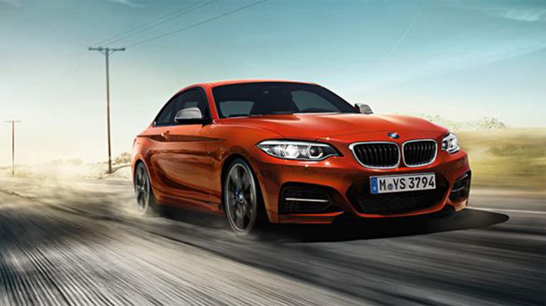 An orange BMW 2 Series driving on a highway