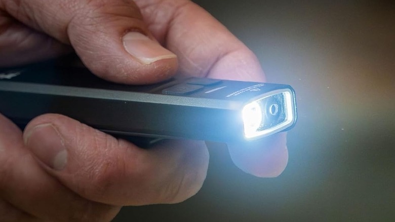 A man holding compact flashlight