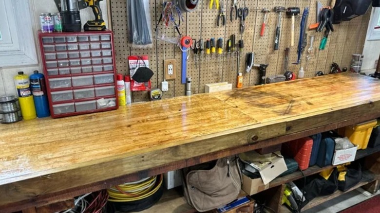 Butcher block workbench top surrounded by tools  in garage