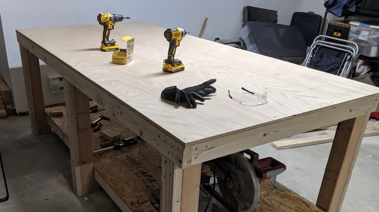 Workbench with plywood top and DeWalt tools in garage