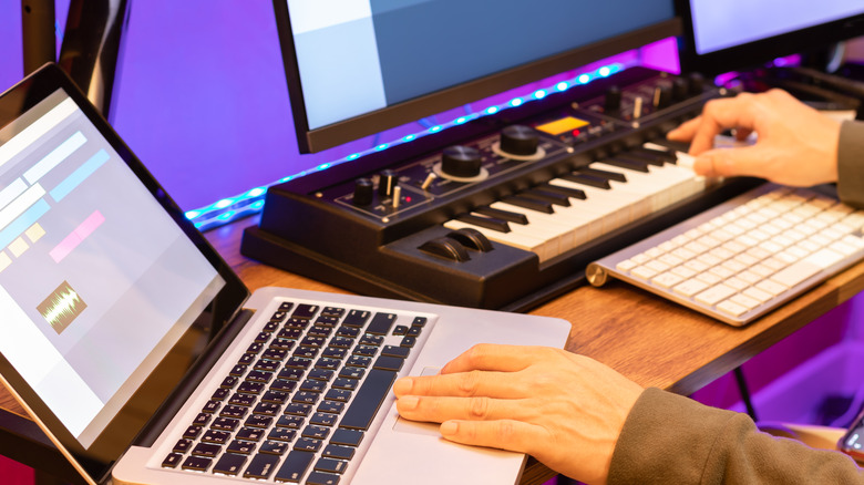 Person using laptop and MIDI keyboard