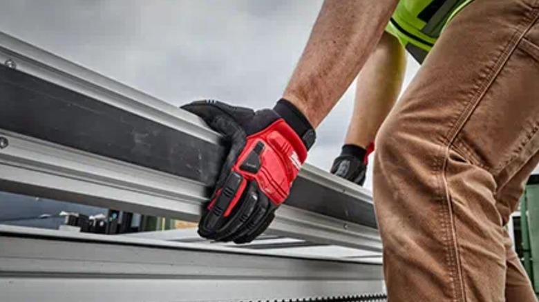 person lifting metal in Milwaukee gloves
