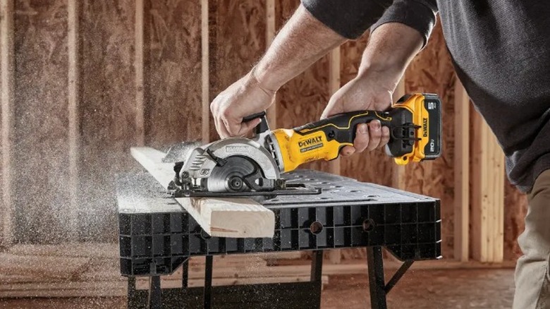 Person cutting 2x4 with a DeWalt Atomic 20V Max 4 ½-inch Circular Saw
