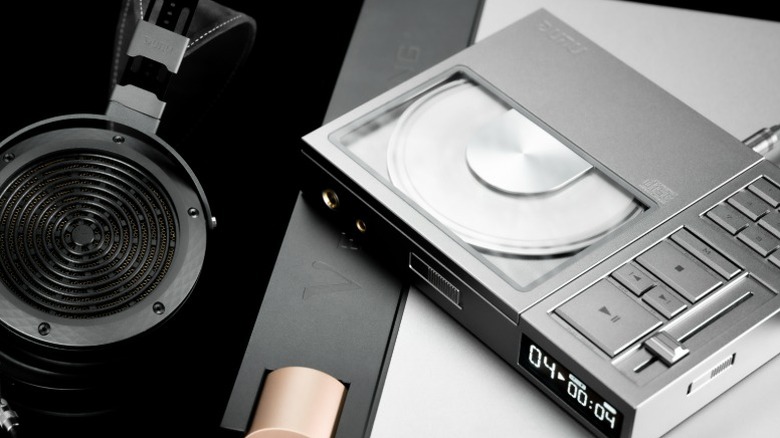 Dunu Concept R placed on a headphone amplifier next to a pair of headphones.