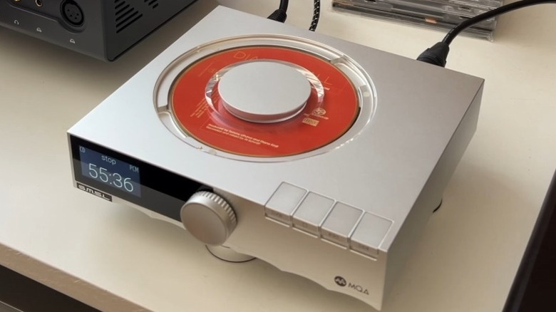 SMSL PL200 on a table surrounded by CDs and other hi-fi gear.