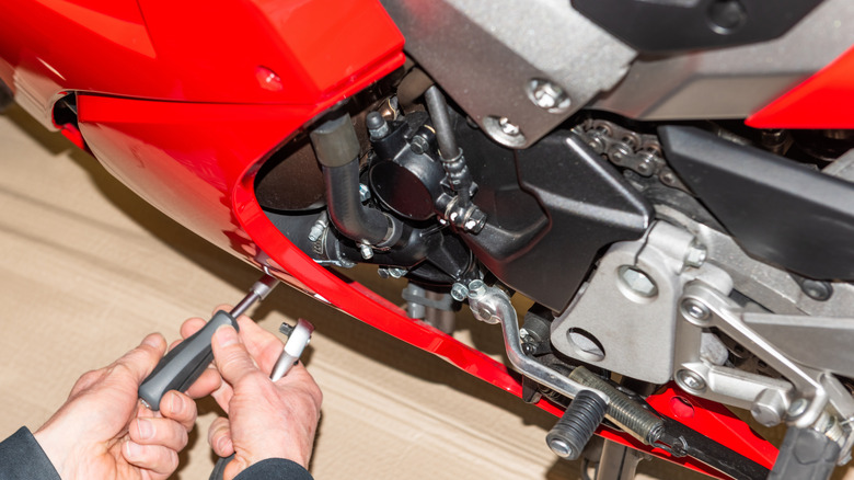 Mechanic bolstering the fairing of a motorcycle