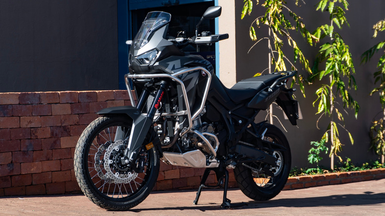 A black Honda Africa Twin motorcycle parked on the pavement