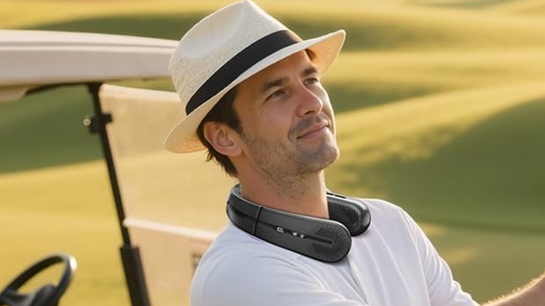 man in golf course with neck fan