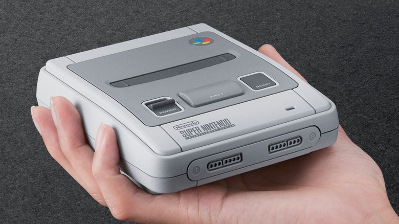 A person holding the Super Nintendo Classic Mini