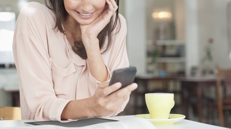 woman using phone on table