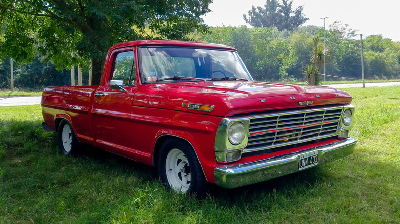 A 1960 Ford F-100 parked in front of a tree
