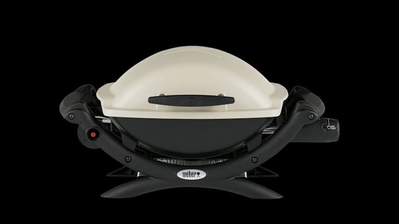 Weber Q 1000 with white lid on black backbackground