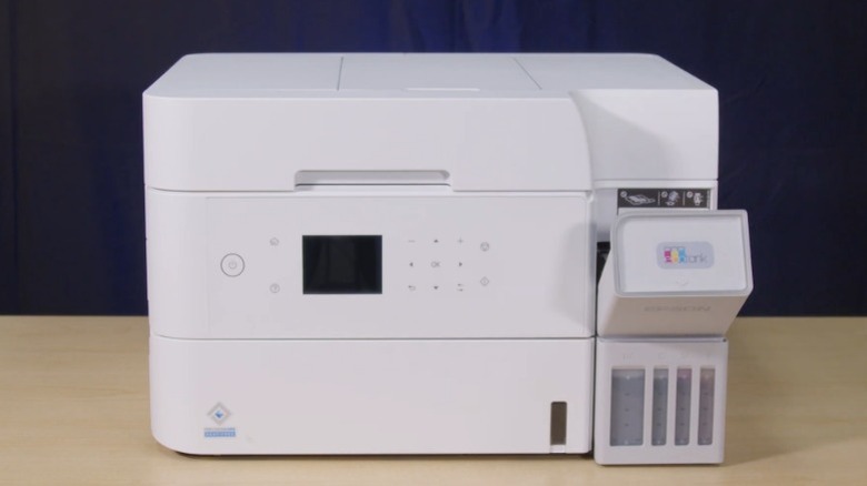 Epson Ecotank ET-3958 printer on a wood table in front of a dark blue background