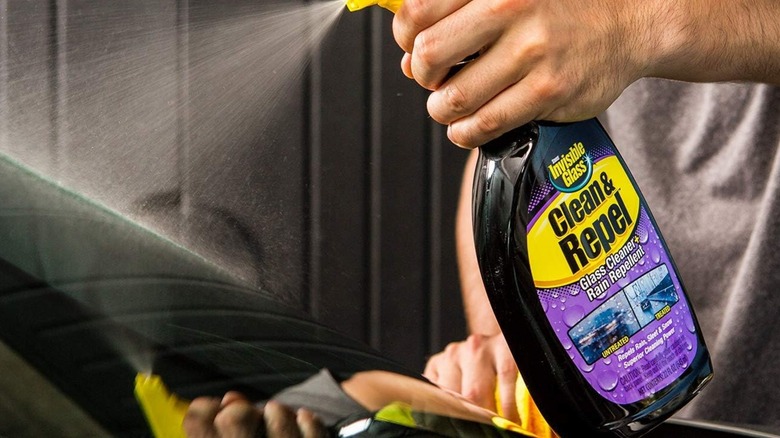 Person using Invisible Glass Clean & Repel spray
