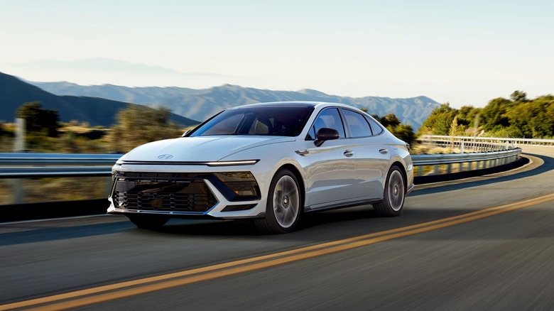 A three quarters frontal shot of a white 2026 Hyundai Sonata driving