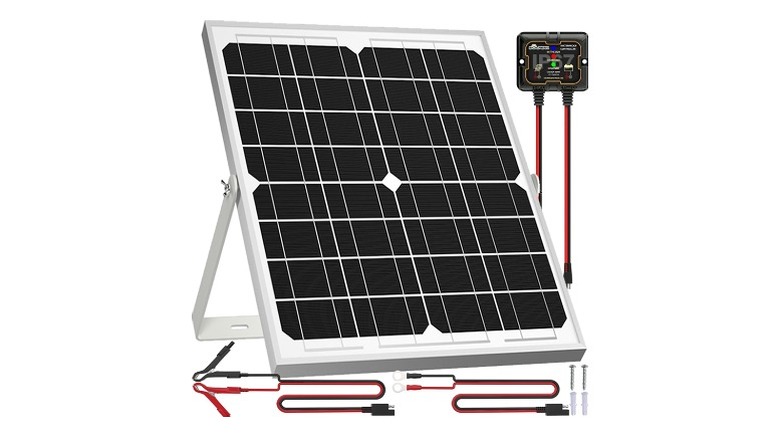 Solar panels mounted at an angle next to wires and a charge controller