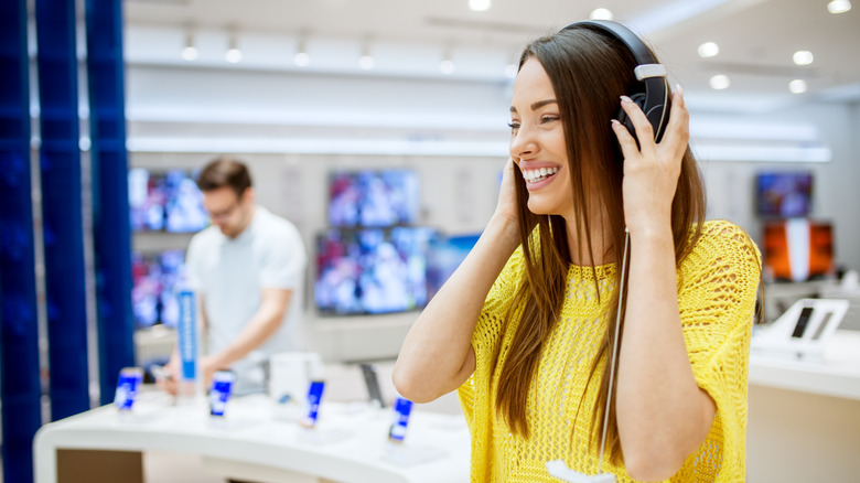 woman testing headphones at store