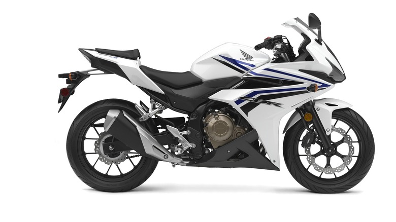 A white Honda CBR500R sitting clean and simple, with blue graphics showing off its sporty fairings.