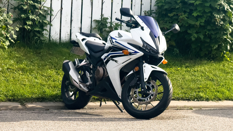 A blue and white Honda CBR500R parked outside