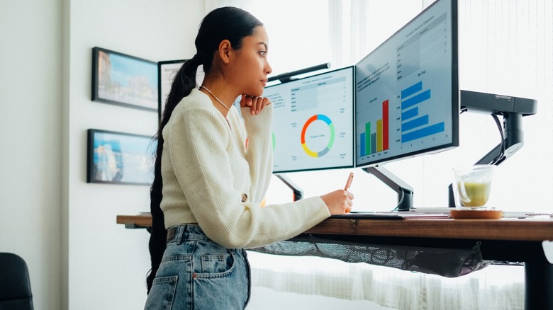 woman using dual monitors on standing desk